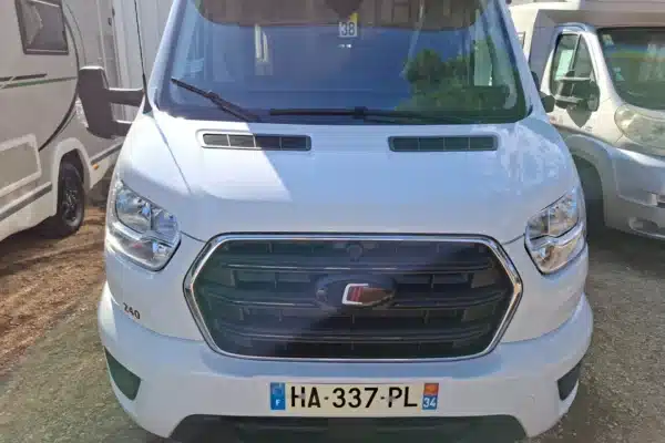 Camping-car blanc vu de face sur parking